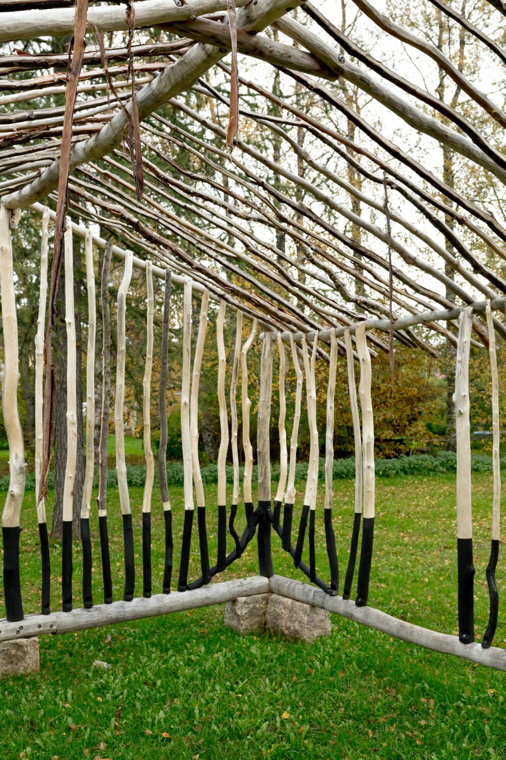 Puumateriaalista paikalla rakennettu teos puistossa, teoksen muoto viittaa pientalovaltaiseen sijaintiympäristöön